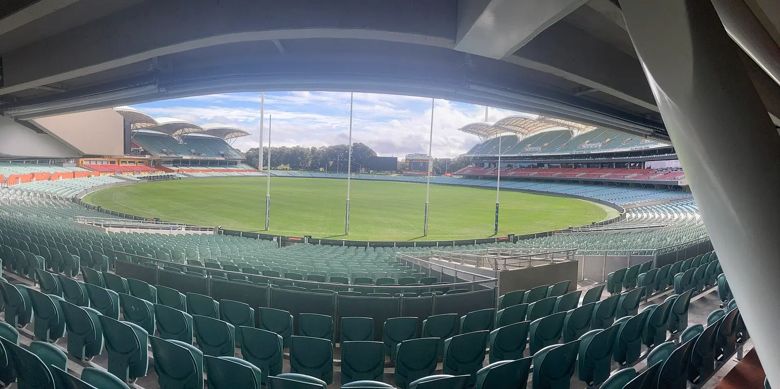 Wide view across the grass of Adelaide Oval toward the goalposts and grandstands