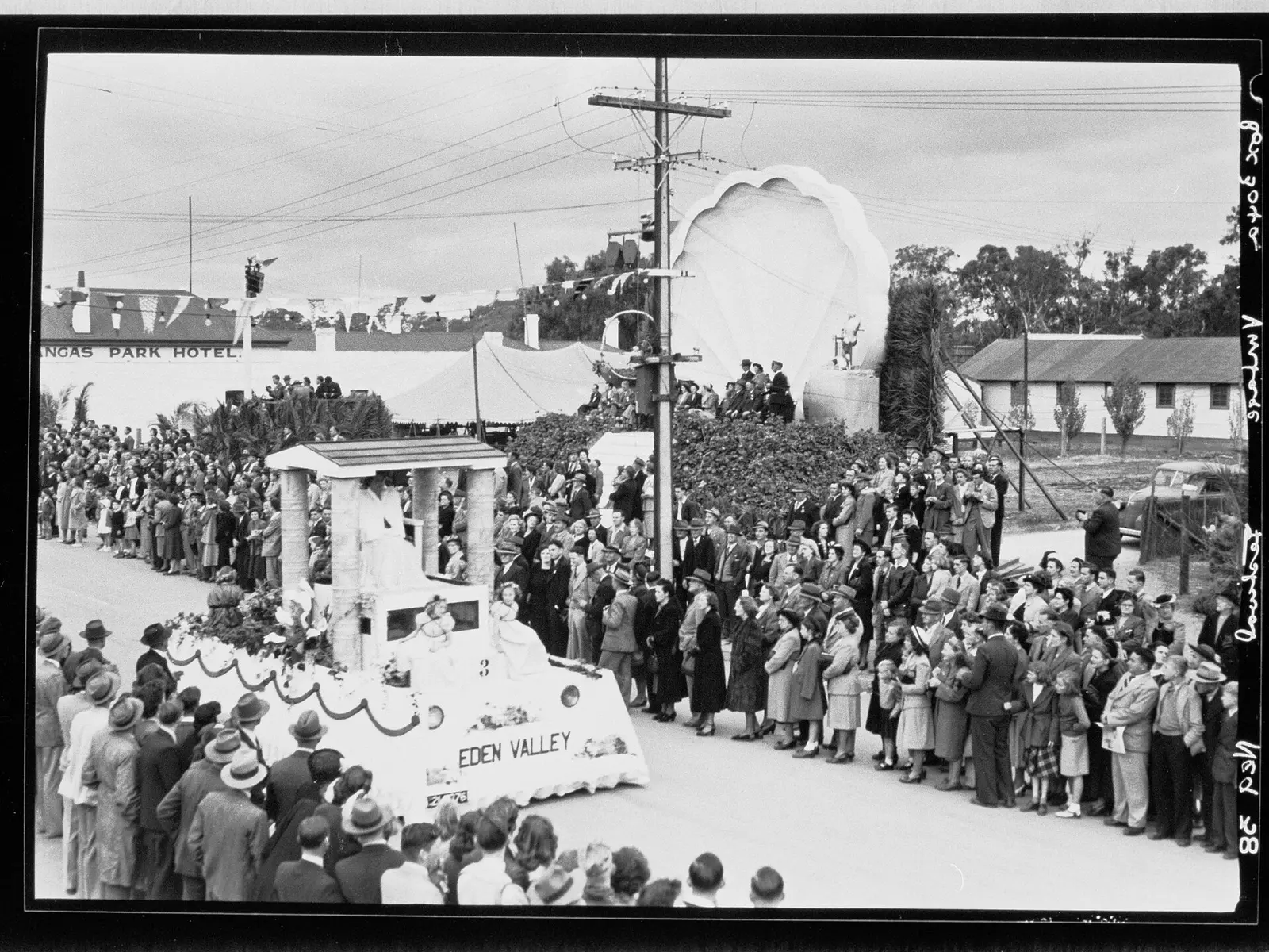 A crowd lines the street to watch a decorated float at the Barossa Vintage Festival at Nuriootpa in 1949