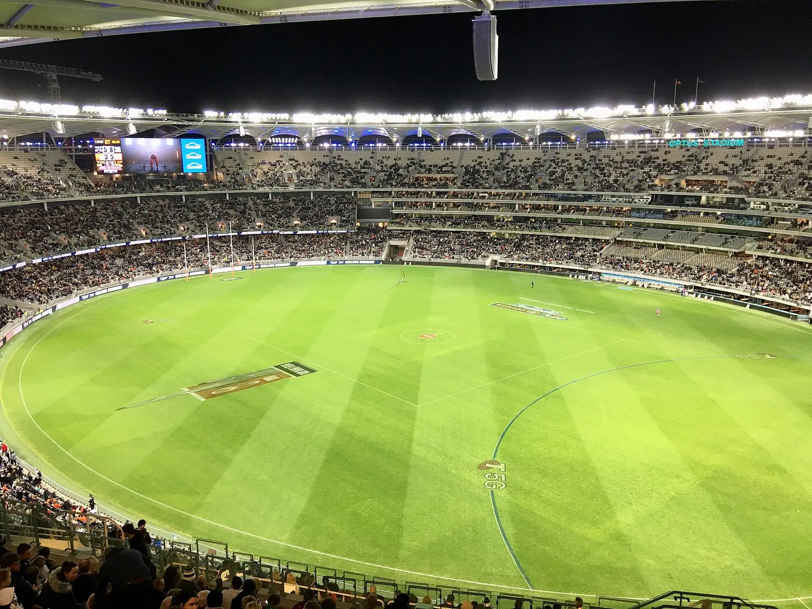 The green playing surface and tiered stands of Optus Stadium in Perth during an AFL final