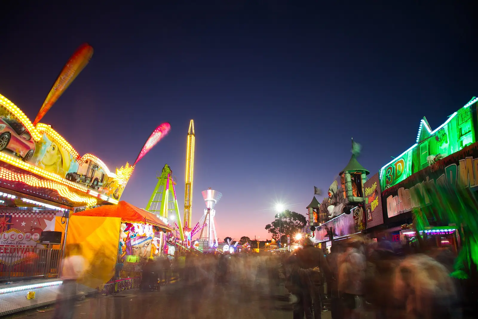 Funfair rides and stalls lit up at dusk at the Perth Royal Show, Claremont