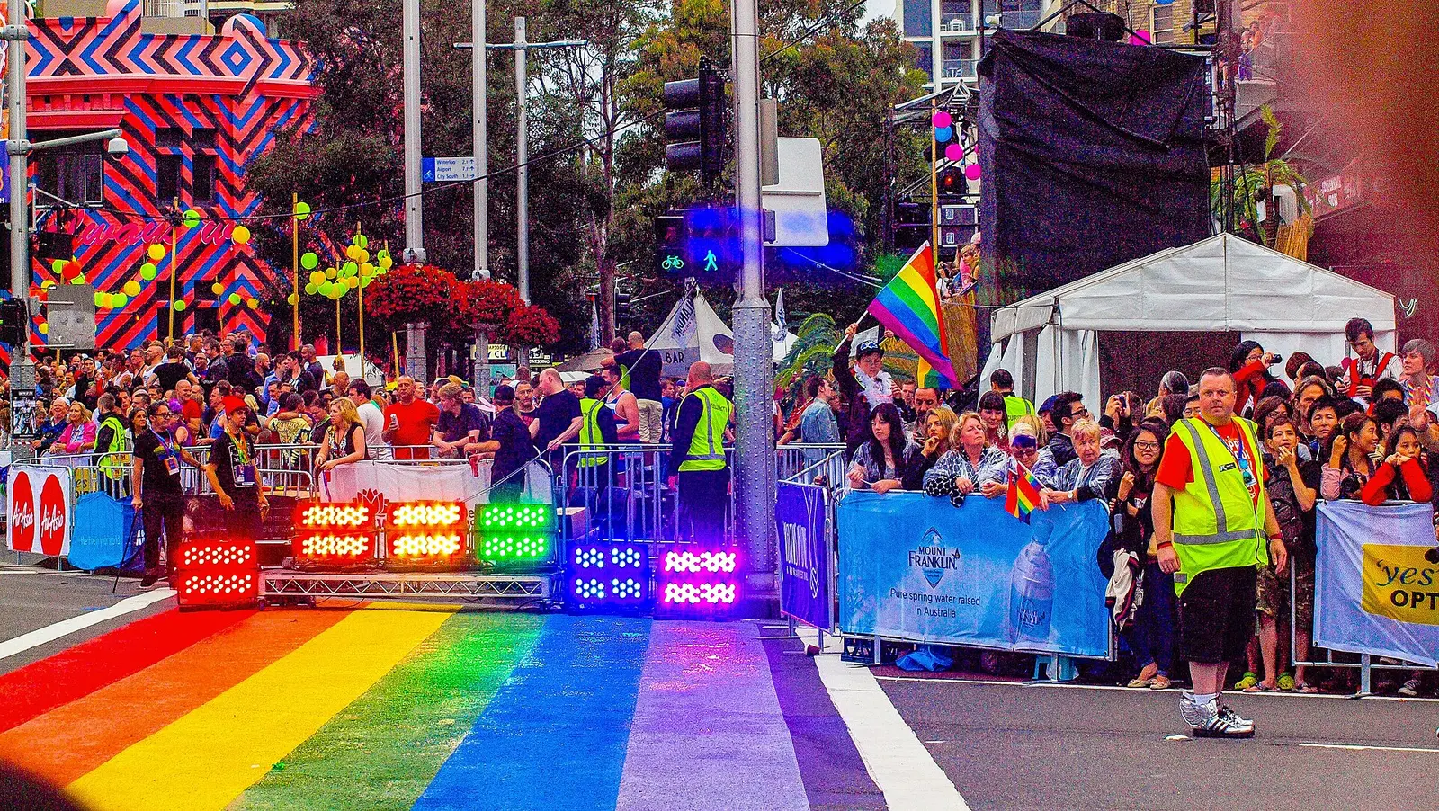 Crowds lining Oxford Street beside a rainbow-painted crossing during the 2013 Sydney Mardi Gras